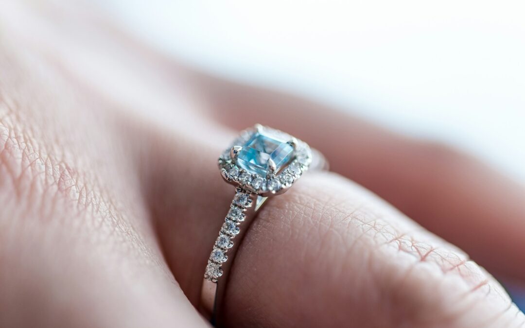 person showing silver-colored ring with gemstone